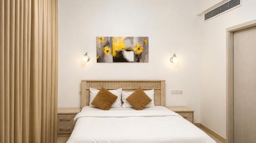 a bedroom with a bed with white sheets and pillows at Lake View By Bait Zain in As Sīfah