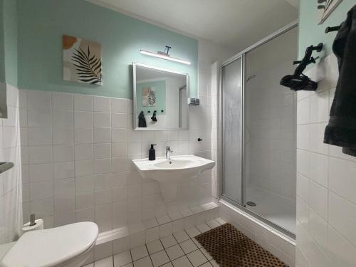a white bathroom with a sink and a shower at Basement Rotherbaum in Hamburg