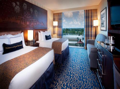 a hotel room with two beds and a large window at Hotel Rosewood Suites Near Delhi IGI Airport in New Delhi