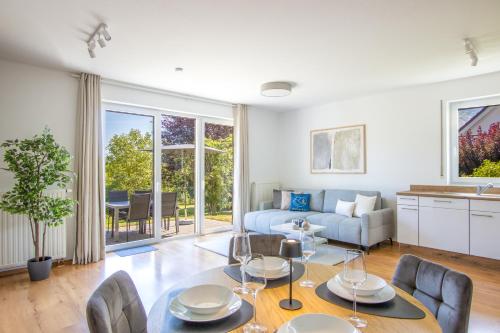 a living room with a table and chairs and a couch at Ferienwohnungen Möhnesee - zentral, stilvoll und ruhig mit Balkon und Boxspringbetten in Möhnesee