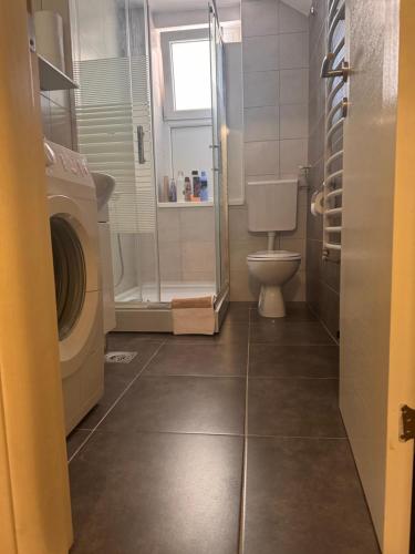 a bathroom with a washing machine and a toilet at KMB suite in Nikšić