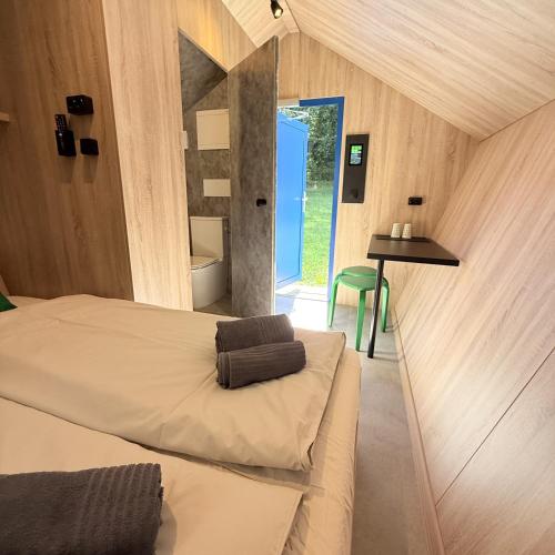 a bedroom with a bed and a table and a window at Glamping chatky in Spišské Tomášovce