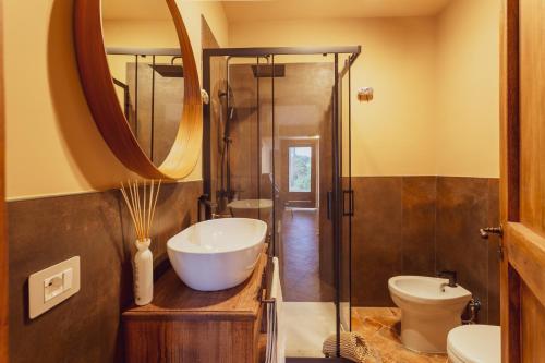 a bathroom with a sink and a toilet and a mirror at Tenuta di Monte Gemini in Campagnano di Roma