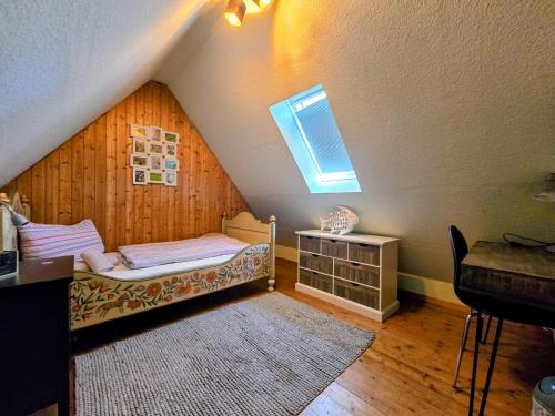 a attic room with a bed and a window at HR Townhouse Honigbach in Coesfeld