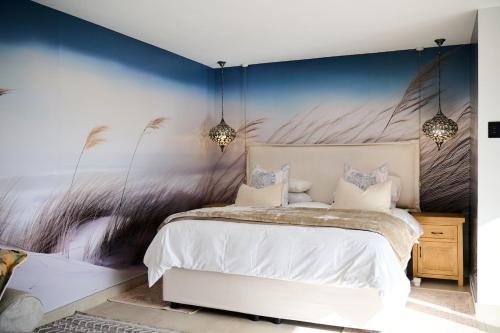 a bedroom with a bed and a wall with a mural at Wish You Were Here! in Wilderness