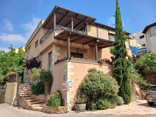 a house with a balcony on top of it at Art & View Family Jacuzzi Suite with Balcony in Maghār