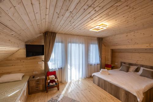 ein Schlafzimmer mit einem großen Bett in einem Holzzimmer in der Unterkunft Arhondaric in Rucăr