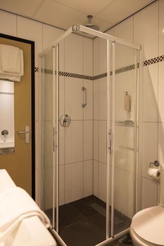een glazen douche in een badkamer met toilet bij Forest Hotel in Den Helder