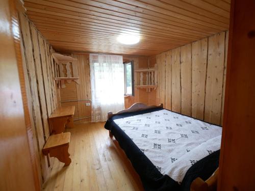 a bedroom with a bed in a wooden cabin at KarpatskeDzerelo in Roztoky