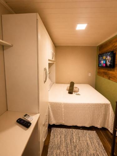 a small room with a bed and a cabinet at Chalé Diamante c /AR in Volta Redonda