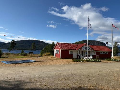 a red building with a flag in front of it at Longerak Camping in Bygland