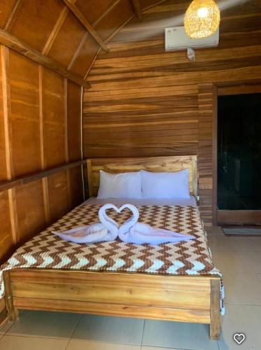 a bed with two swans forming a heart at Awang Homestay in Bumbang