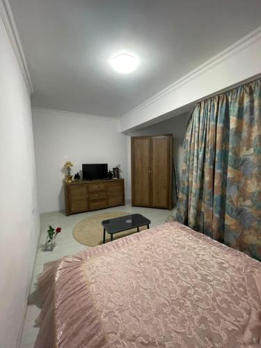 a bedroom with a bed and a dresser and a television at Solid House Apartment - Sea View in Mamaia