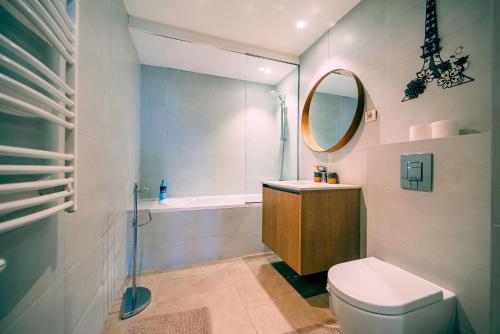 a bathroom with a toilet and a sink and a mirror at BW Cityline Residences in Belgrade