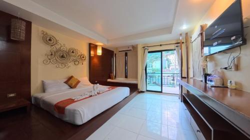 a hotel room with a bed and a television at Azure Stays Patong in Patong Beach