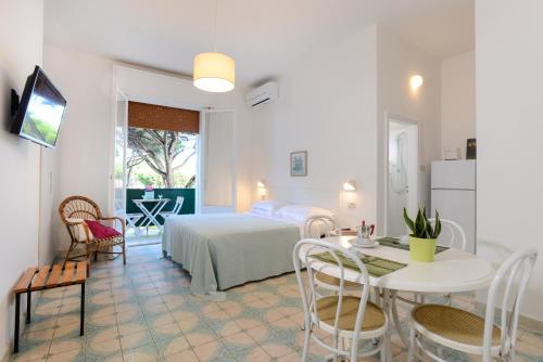 a bedroom with a bed and a table and chairs at Residence delle Nazioni - Spiaggia privata su richiesta in Principina a Mare