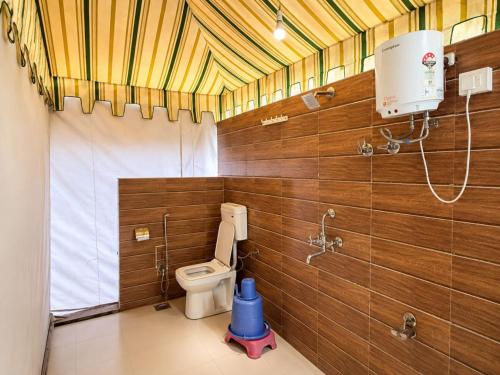 a bathroom with a toilet and a shower in it at Unity Holiday Resort in Kevadia