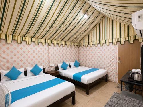 a room with two beds in a room at Unity Holiday Resort in Kevadia