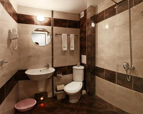 a bathroom with a toilet and a sink and a mirror at JBH Hotel in Sveti Vlas