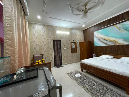a bedroom with a bed and a large painting on the wall at Omkara Villa Sonipat in Sonīpat