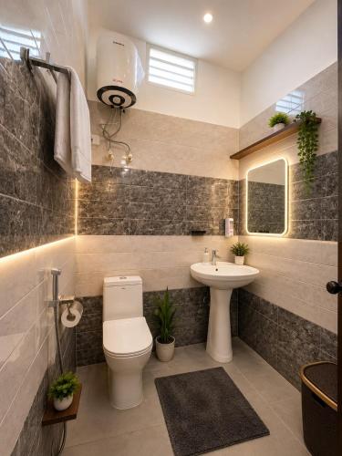a bathroom with a toilet and a sink at Omkara Villa Sonipat in Sonīpat