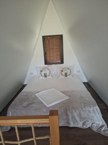 a bed in a room with a window at RanyA-Frame in Nucşoara