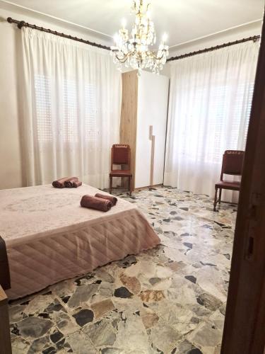a bedroom with a bed and a chandelier at Torres House Suite & Rooms in Sassari