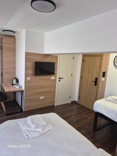 a bedroom with a bed and a desk and a television at Stari Grad in Kragujevac