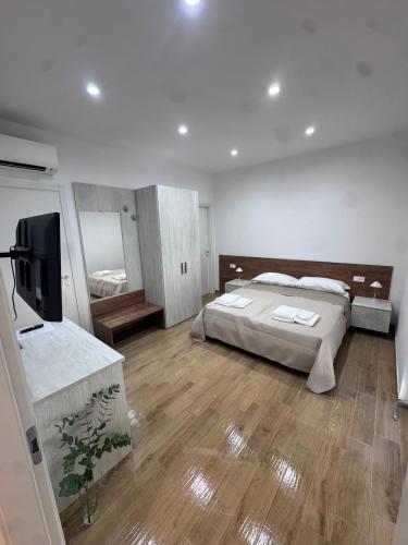 a bedroom with a bed and a flat screen tv at Les chambres de Nancy in Contursi Terme