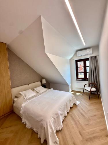 a bedroom with a white bed in a attic at Apartmán Thea in Komárno