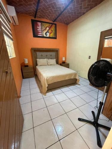 a bedroom with a bed and a fan on a tiled floor at Hotel Santa Cecilia in Villa Corona