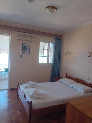 a bedroom with a bed with two towels on it at FAFALIOS Studios in Vrontádos
