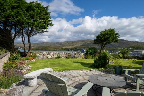 a patio with a table and chairs and a garden at Two Harbours Guest House in Scalpay