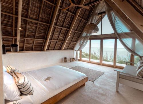 a bedroom with a bed and a large window at Tao Resort in Andavakonko