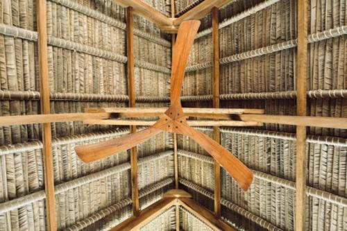 a ceiling fan hanging from a wall with books at Tao Resort in Andavakonko