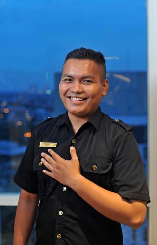 a man in a black shirt holding a credit card at Midtown Residence Surabaya in Surabaya