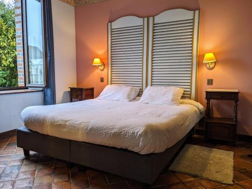 a bedroom with a large bed and a window at Gîtes du Martroy in Nargis