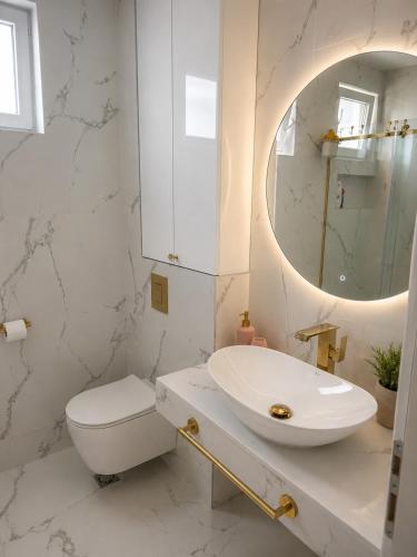 a white bathroom with a sink and a mirror at Apart-pool Tivat in Tivat