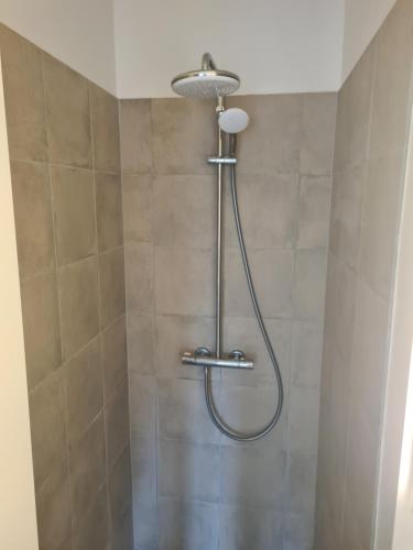 a shower with a shower head in a bathroom at Hotel Damm in Aalborg