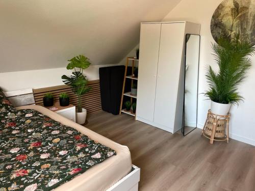 a bedroom with potted plants and a bed and a mirror at Deep Blue Dümmer - Apartment in Lembruch