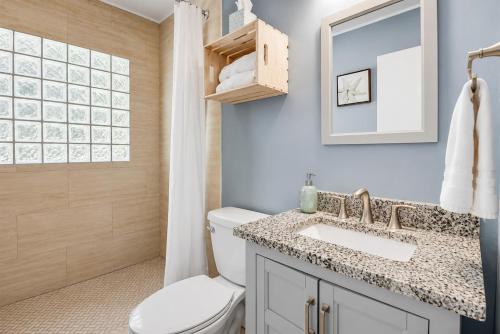 a bathroom with a toilet and a sink and a mirror at The Crystal River House in Crystal River