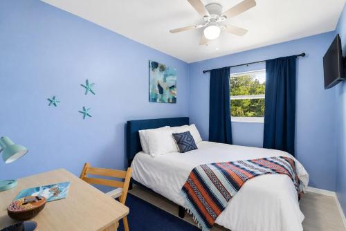 a bedroom with blue walls and a bed and a table at The Crystal River House in Crystal River
