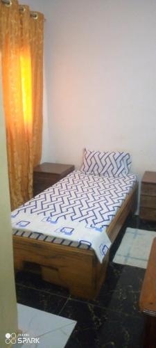 a bed sitting in a room with a curtain at Chambre d'hôtes à louer in Pikine