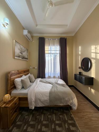 a bedroom with a large bed and a window at HM Homes in Morogoro
