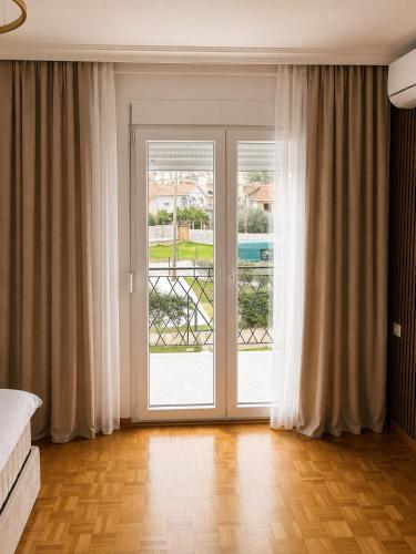 a room with a large sliding glass door with a balcony at Apart-pool Tivat in Tivat