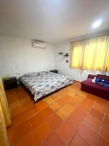 a bedroom with a bed and a couch in it at Entre Pajaros y Flores in Rivera