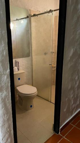 a bathroom with a toilet and a glass shower at Entre Pajaros y Flores in Rivera