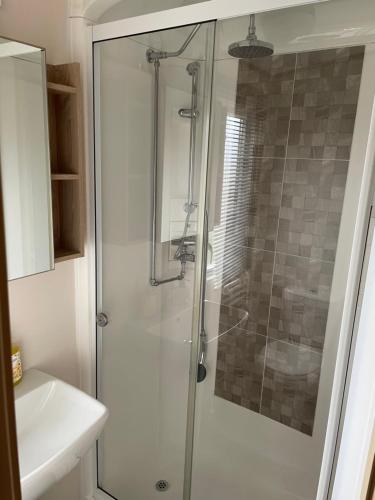 a bathroom with a shower and a sink at Sunset View - with view of the lighthouse and a shower and bath in Lossiemouth