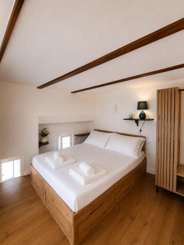 a bedroom with a large white bed with white sheets at Suite Il Mulino - Sea View in Sperlonga