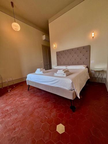 a large bed in a room with a red floor at Augusta e Libero Apartments in Spoleto